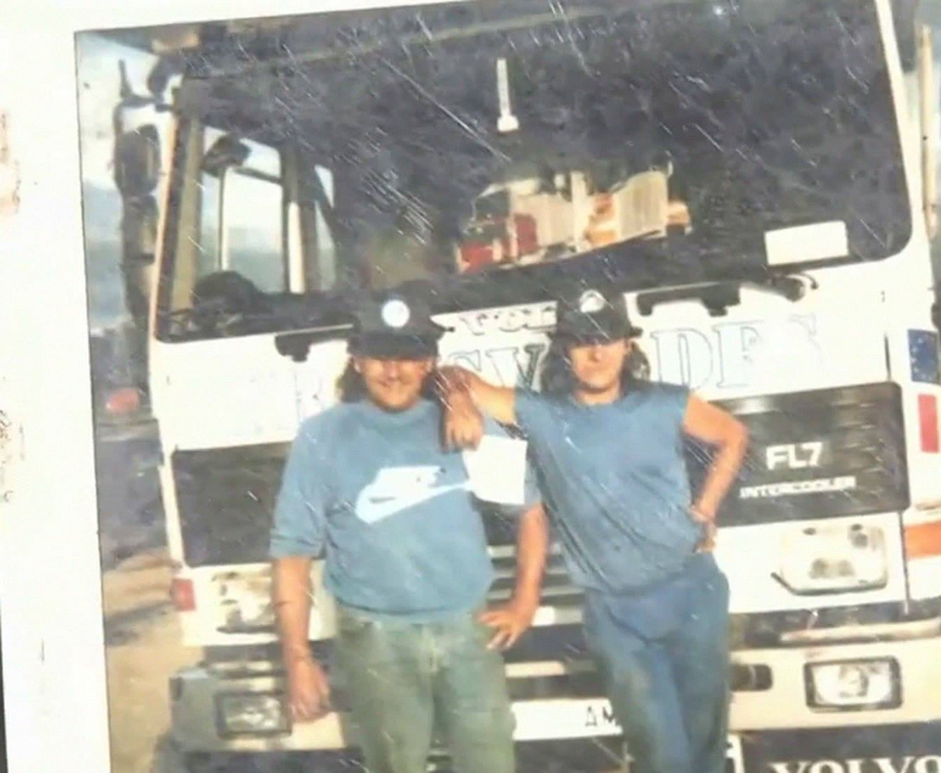 Foto antigua de dos hombres jóvenes delante de un camión Volvo FL7